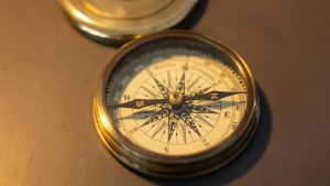Mentoring Close-up of a vintage brass compass, emphasizing its nautical design and retro charm.