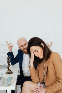Mentoring Two colleagues in a law office engaging in a tense discussion, showcasing frustration and stress.